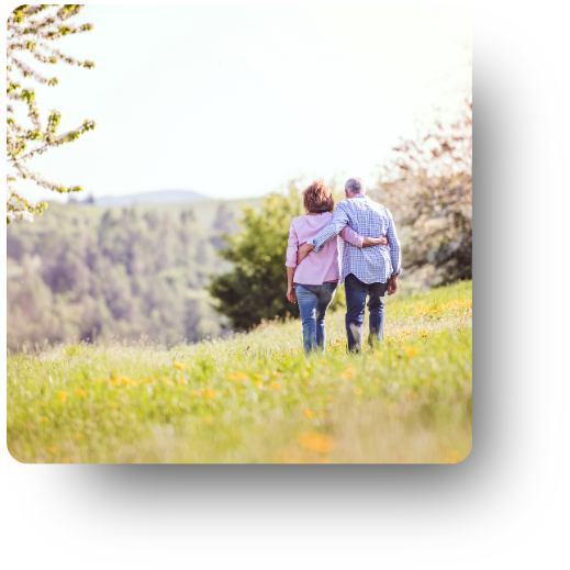 Older couple walking together through open land